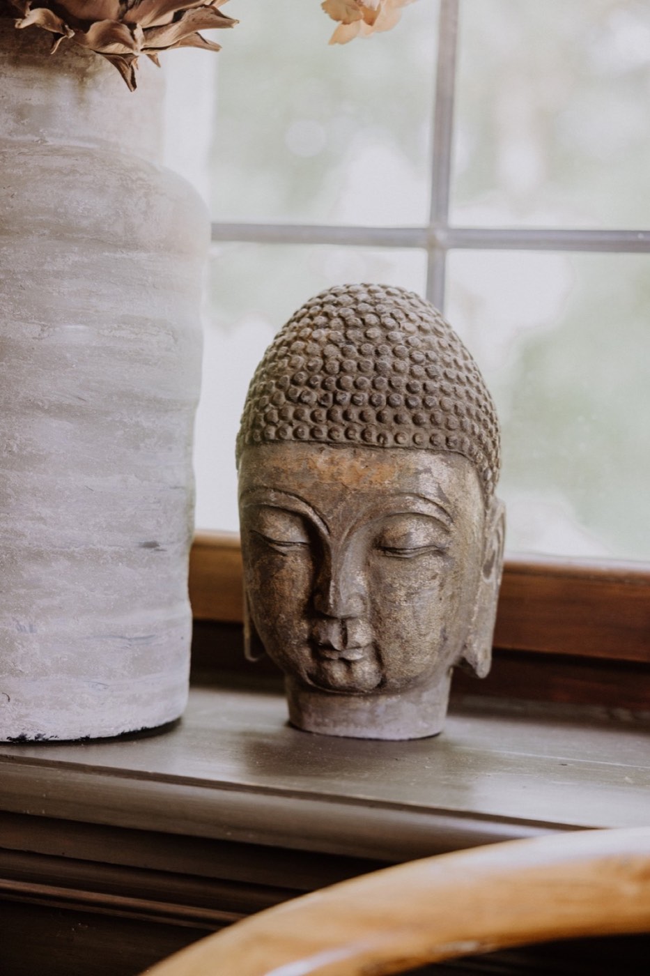 Buddha-Kopf als dekoratives Einzelstück auf einer Fensterbank